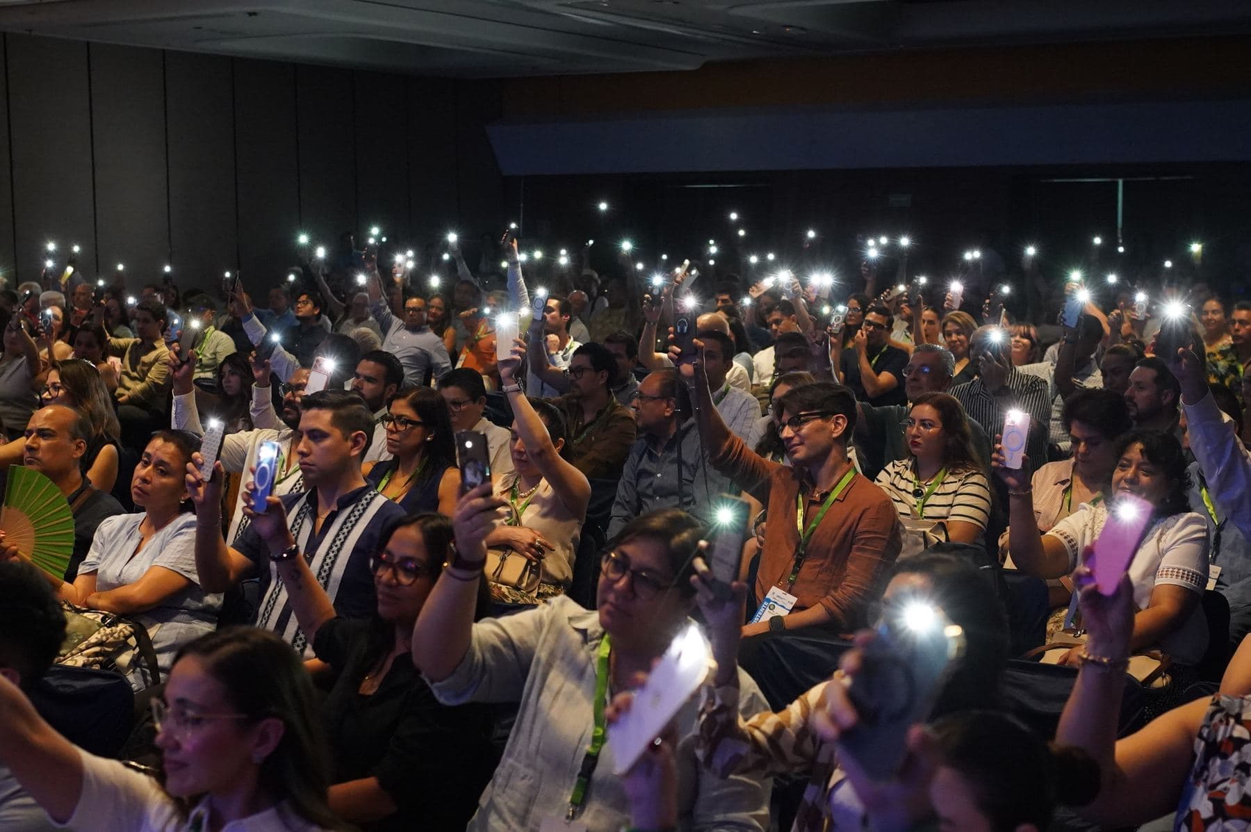 Auditorio lleno con las luces de los teléfonos encendidas